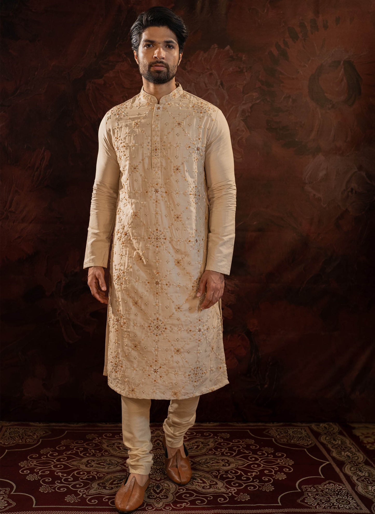Beige Silk Kurta with all over hand done french knot embroidery with mustard and maroon highlights. Comes with Churidar.