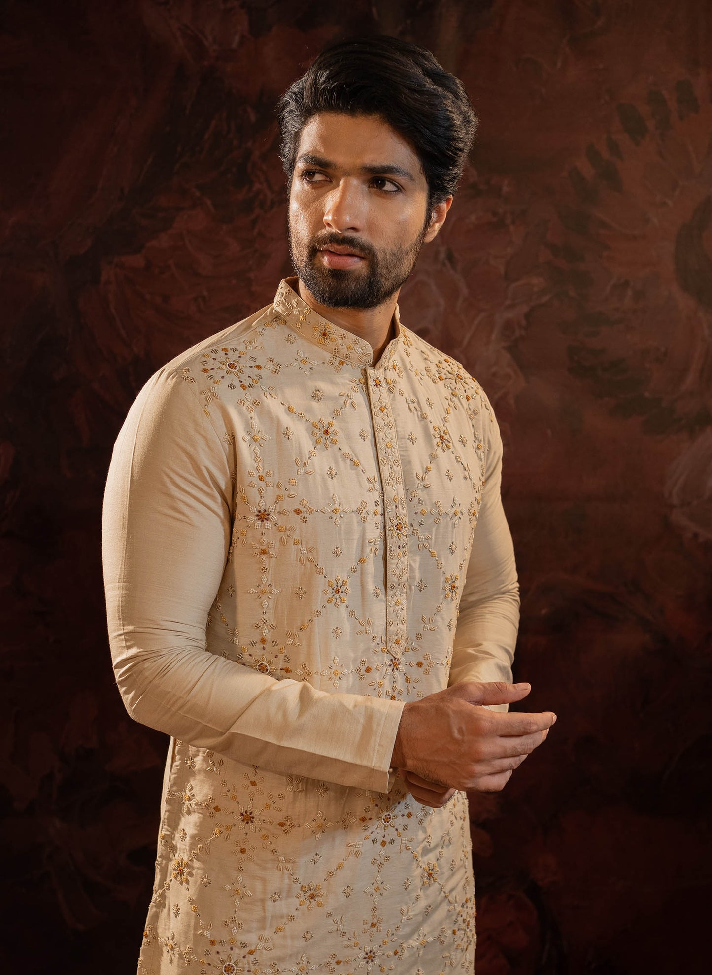 Beige Silk Kurta with all over hand done french knot embroidery with mustard and maroon highlights. Comes with Churidar.
