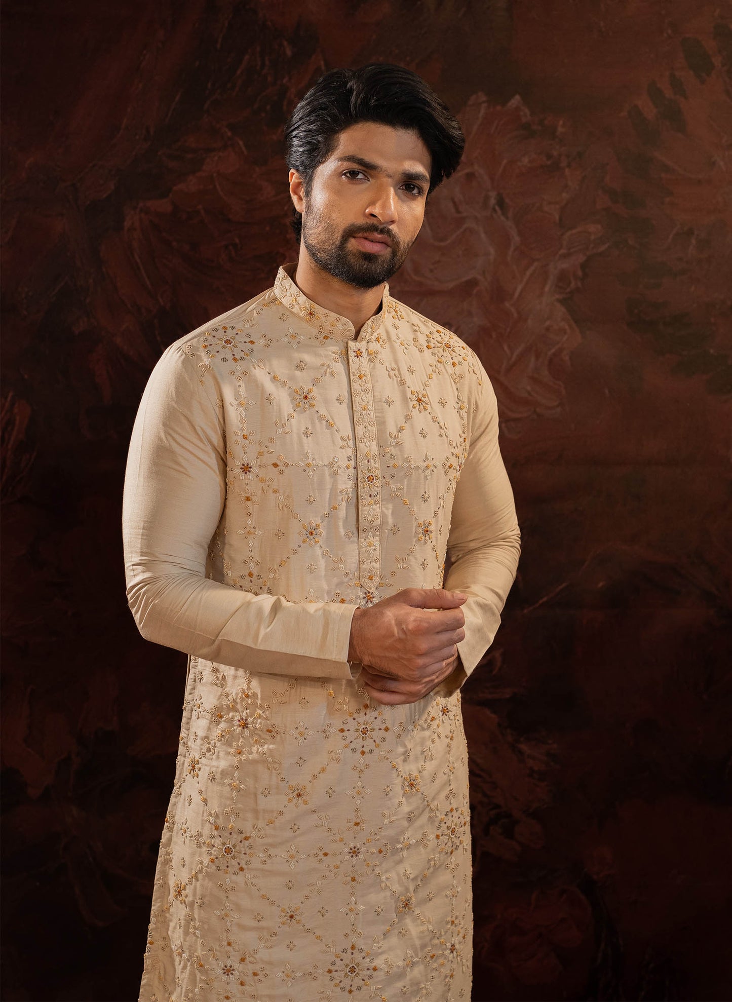 Beige Silk Kurta with all over hand done french knot embroidery with mustard and maroon highlights. Comes with Churidar.